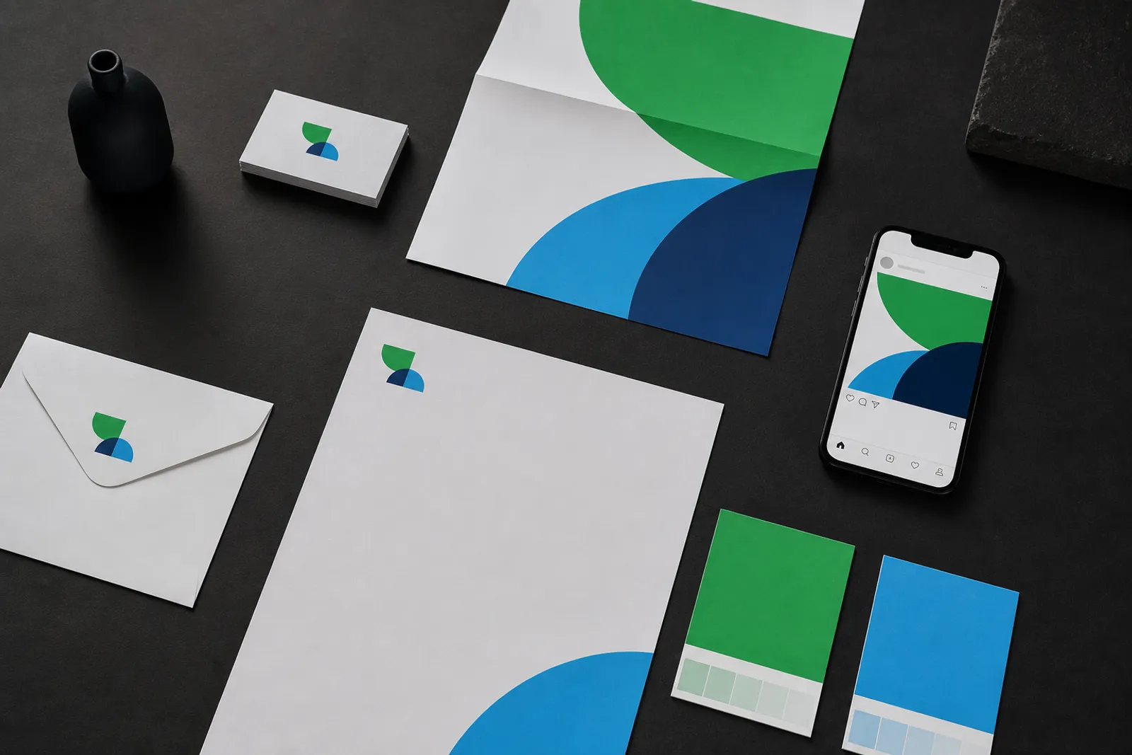 Flat-lay of brand identity materials: business card, color swatches, poster, stationery, and phone social post